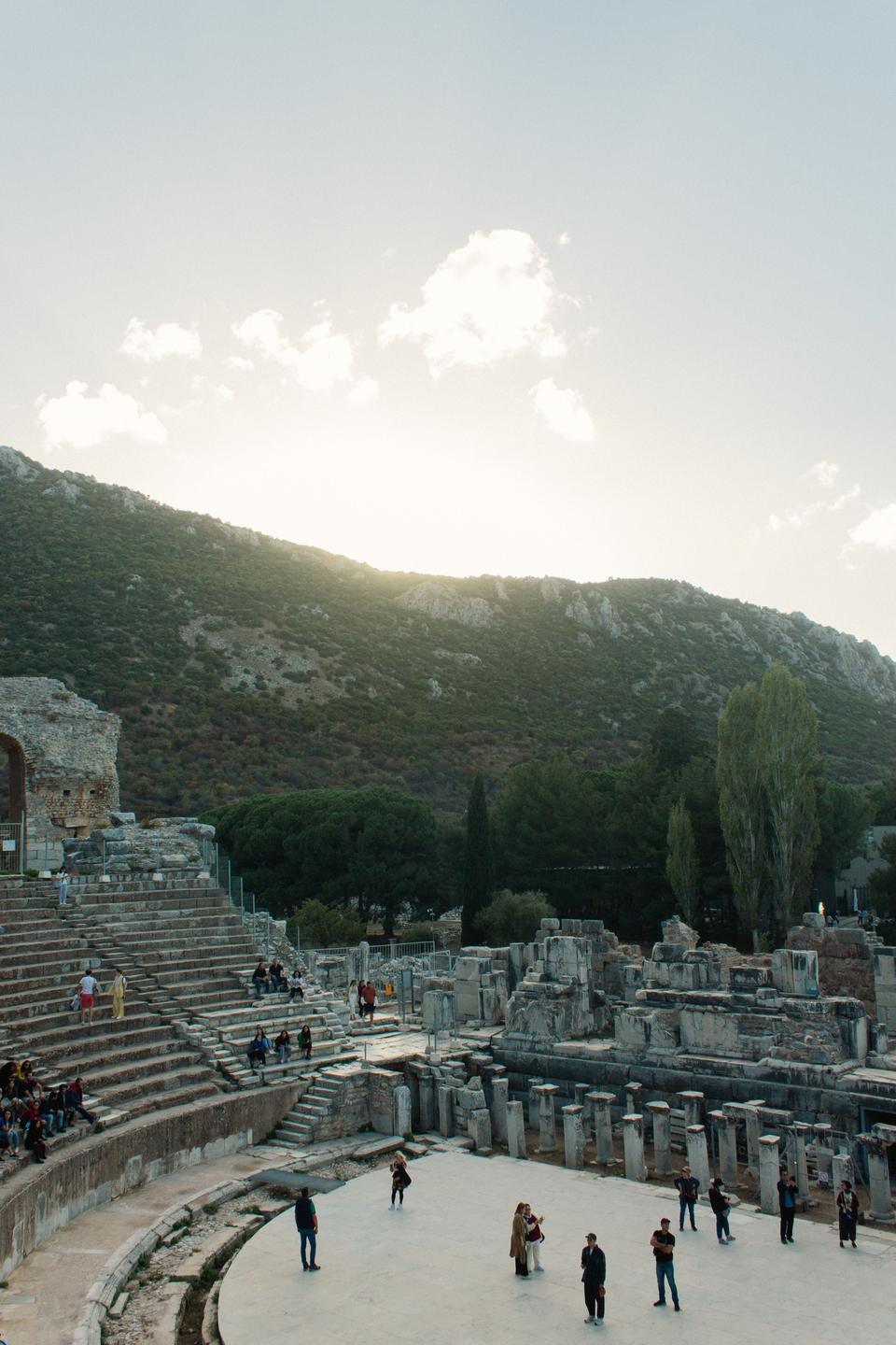 Visitors standing in the Great Theater's orchestra beside the ruined stage building