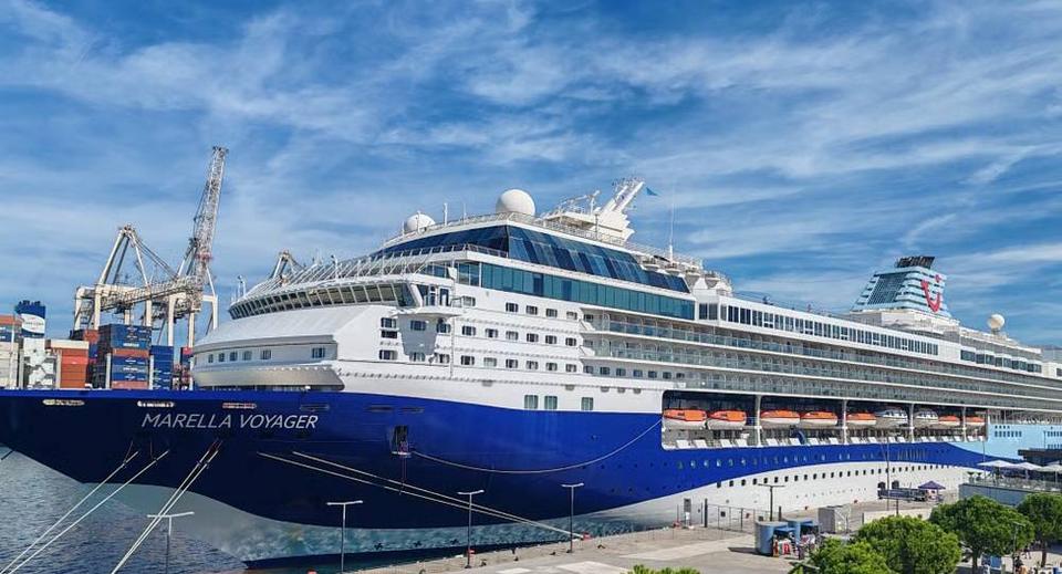 Marella Voyager cruise ship with a dark blue hull moored beside port cranes